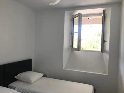 a bedroom with a bed and a window at Cannes 2 pieces de 49 m2 ,piscine. Jardin privatif in Cannes