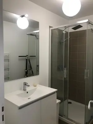 a bathroom with a sink and a glass shower at Cannes 2 pieces de 49 m2 ,piscine. Jardin privatif in Cannes