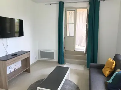 a living room with a couch and a tv and a window at Cannes 2 pieces de 49 m2 ,piscine. Jardin privatif in Cannes