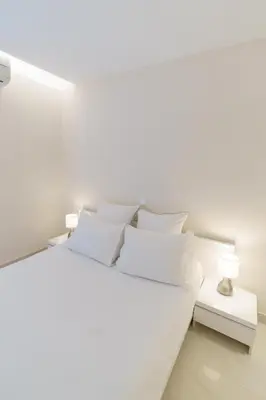a white bedroom with a white bed with white pillows at Cannes: superbe appartement de type T2 pour 4 pers in Cannes