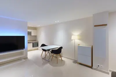 a kitchen with a table and two chairs and a television at Cannes: superbe appartement de type T2 pour 4 pers in Cannes
