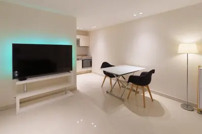 a living room with a tv and a table and chairs at Cannes: superbe appartement de type T2 pour 4 pers in Cannes