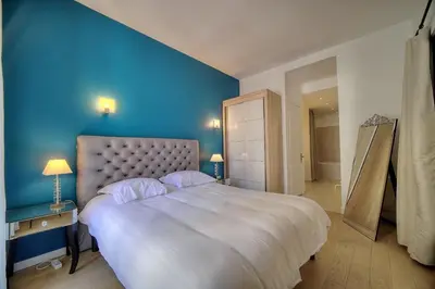 a bedroom with a large bed with a blue wall at Superbe 2 chambres BALCON, COEUR DE CANNES- CENTRE VILLE A2B233 in Cannes