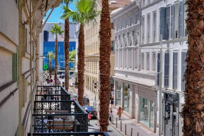 a view of a street with palm trees and buildings at Superbe 2 chambres BALCON, COEUR DE CANNES- CENTRE VILLE A2B233 in Cannes
