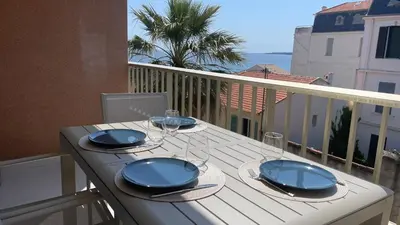 a table on a balcony with blue dishes on it at Cannes Pointe Croisette : superbe logement vue mer in Cannes