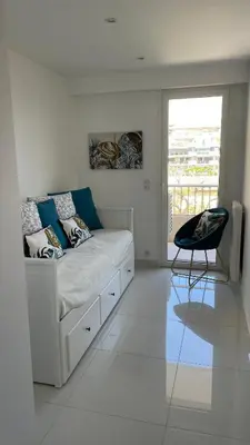 a white room with a couch and a chair at Cannes Pointe Croisette : superbe logement vue mer in Cannes