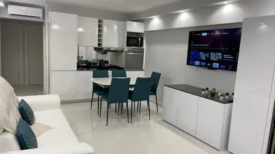 a kitchen and living room with a table and chairs at Cannes Pointe Croisette : superbe logement vue mer in Cannes