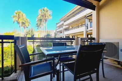 a patio with a table and chairs on a balcony at Cannes Conseil Immo -Résidence avec piscine, appartement avec terrasse pour 4 personnes in Cannes
