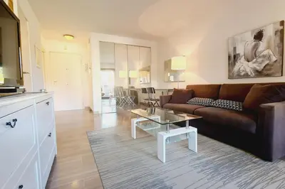 a living room with a couch and a table at Cannes Conseil Immo -Résidence avec piscine, appartement avec terrasse pour 4 personnes in Cannes