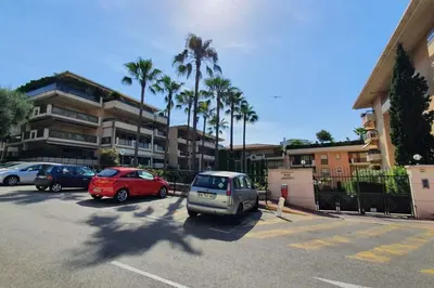 a parking lot with cars parked in front of a building at Cannes Conseil Immo -Résidence avec piscine, appartement avec terrasse pour 4 personnes in Cannes