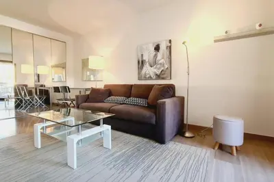 a living room with a couch and a table at Cannes Conseil Immo -Résidence avec piscine, appartement avec terrasse pour 4 personnes in Cannes