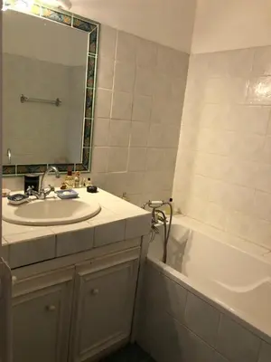 a bathroom with a sink and a tub and a mirror at Maison au calme avec jardin et garage proche du centre et de la mer in Cannes