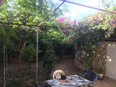 a garden with a table and chairs and flowers at Maison au calme avec jardin et garage proche du centre et de la mer in Cannes