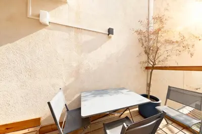 a table and chairs in a room with a wall at VILLA MARINA CANNES in Cannes