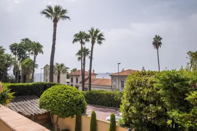 a view from the balcony of a house with palm trees at Superb villa with swimming pool & sauna in Cannes