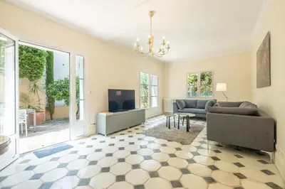 a living room with a couch and a tv at Superb villa with swimming pool & sauna in Cannes