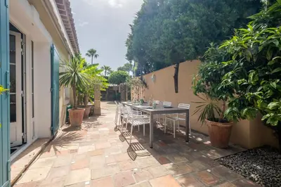a table and chairs on a patio with plants at Superb villa with swimming pool & sauna in Cannes
