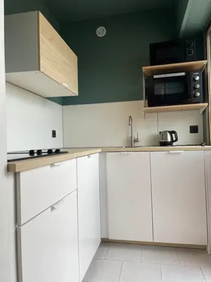 a kitchen with white cabinets and a microwave at RoofTop Apartement - Quartier Croisette - Esc'Appart in Cannes