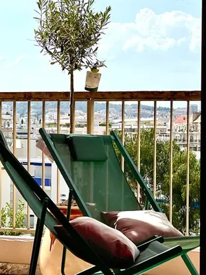 a green chair sitting on a balcony with a view at RoofTop Apartement - Quartier Croisette - Esc'Appart in Cannes