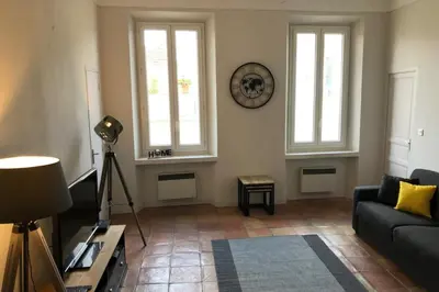 a living room with a couch and two windows at Old city - very charming 1-bedroom apt in Cannes