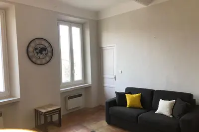 a black couch with two yellow pillows in a living room at Old city - very charming 1-bedroom apt in Cannes