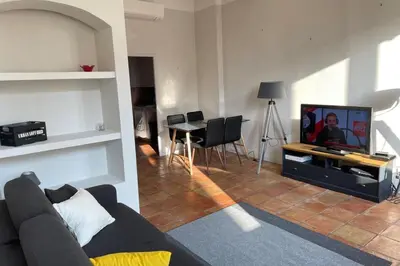 a black couch with two yellow pillows in a living room at Old city - very charming 1-bedroom apt in Cannes