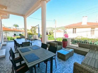 a patio with a table and chairs on a porch at SUPERBE MAISON 6 ch, 4 sdb, terrasses et billard in Cannes