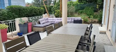 a wooden table and chairs on a patio at SUPERBE MAISON 6 ch, 4 sdb, terrasses et billard in Cannes
