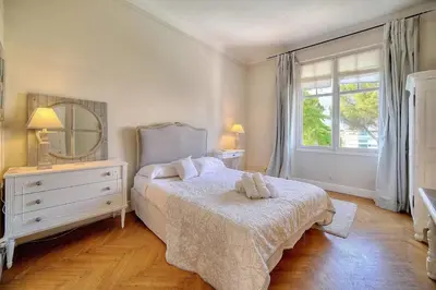 a bedroom with a bed and a mirror and a window at Cannes Luxury Rental - Belle epoque villa to rent close to Cannes center in Cannes