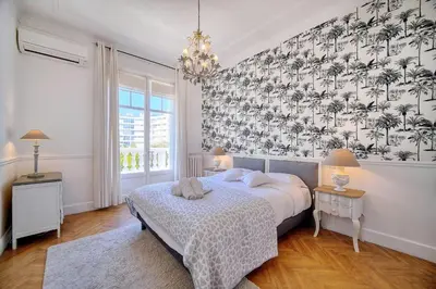 a bedroom with a bed and a wall with palm trees at Cannes Luxury Rental - Belle epoque villa to rent close to Cannes center in Cannes