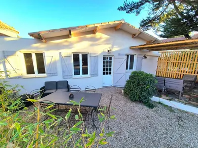 a white house with a picnic table in front of it at CANNES - PETIT JUAS, CHARMANTE VILLA AU CALME, TOUT CONFORT in Cannes
