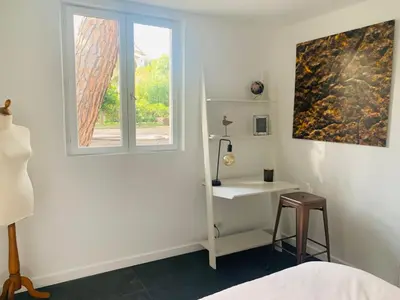 a bedroom with a window and a table and a stool at CANNES - PETIT JUAS, CHARMANTE VILLA AU CALME, TOUT CONFORT in Cannes