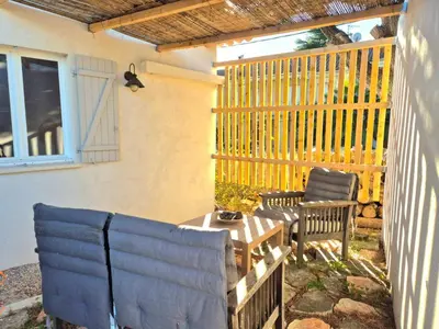 a patio with a blue couch and a table at CANNES - PETIT JUAS, CHARMANTE VILLA AU CALME, TOUT CONFORT in Cannes