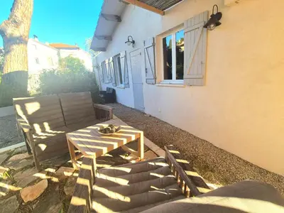 a table and a chair on the side of a house at CANNES - PETIT JUAS, CHARMANTE VILLA AU CALME, TOUT CONFORT in Cannes