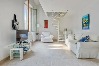 a living room with a white couch and a tv at Appartement Perrissol - Welkeys in Cannes