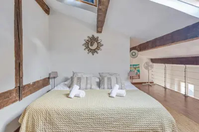 a bedroom with a large bed with white walls at Appartement Perrissol - Welkeys in Cannes
