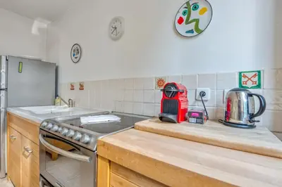 a kitchen with a counter with a stove and a refrigerator at Appartement Perrissol - Welkeys in Cannes