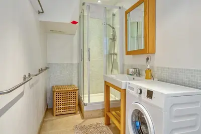 a bathroom with a washing machine and a shower at Appartement Perrissol - Welkeys in Cannes