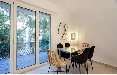 a dining room with a table and chairs and a balcony at Appart 2 pièces Cannes Croisette-Martinez in Cannes