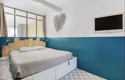 a bedroom with a bed and a tv on a wall at Croisette Beach Cannes Banane 4 sleeps Apart in Cannes