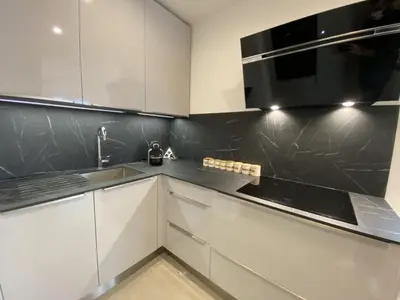 a kitchen with white cabinets and a black counter top at Grand Palais ANT1308 in Cannes