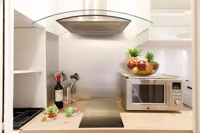 a kitchen with a microwave and a bowl of fruit at Panisse YourHostHelper in Cannes