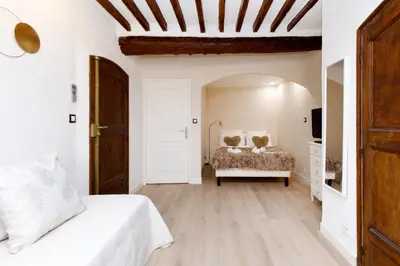 a white bedroom with a bed and a dresser at Panisse YourHostHelper in Cannes