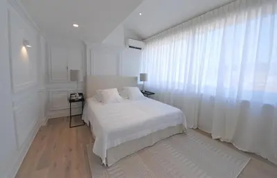a white bedroom with a bed and a window at FOCH Bright prestigious apartment in Cannes ! in Cannes