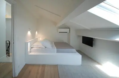 a white bedroom with a bed and a tv at FOCH Bright prestigious apartment in Cannes ! in Cannes