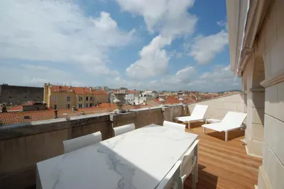 a balcony with a table and chairs on a roof at FOCH Bright prestigious apartment in Cannes ! in Cannes