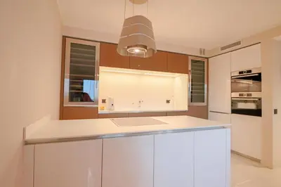 a kitchen with white cabinets and a light fixture at GRAY Renovated luxurious apartment located in Cannes in Cannes