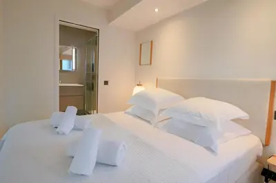 a bedroom with a white bed with white pillows at GRAY Renovated luxurious apartment located in Cannes in Cannes