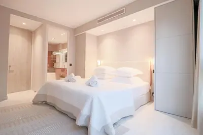 a white bedroom with a bed with white sheets and pillows at GRAY Renovated luxurious apartment located in Cannes in Cannes