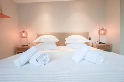 a white bed with pillows and towels on it at GRAY Renovated luxurious apartment located in Cannes in Cannes